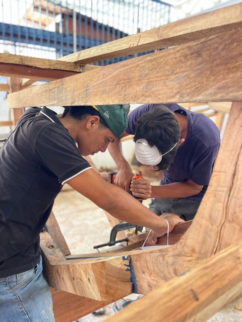 Estudiante con la piragua que construyó